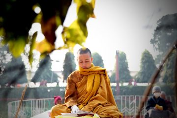 Front Cover. A nun prays at a temple in India
